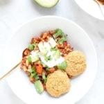 Chili in a white bowl with gluten-free cornbread.