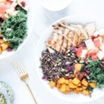 Fall harvest bowl with apples, squash, chicken, kale, and wild rice in two white bowls.