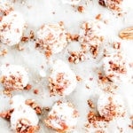 Paleo pumpkin spice donut holes with pecan crunch on parchment paper.