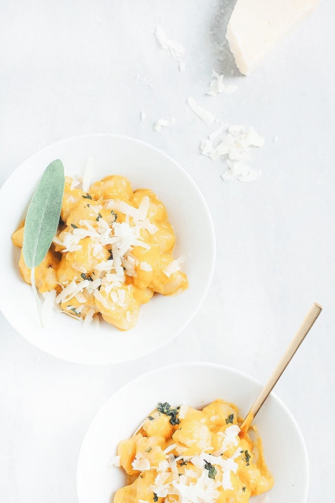 Cauliflower gnocchi with butternut squash sauce in white bowls.