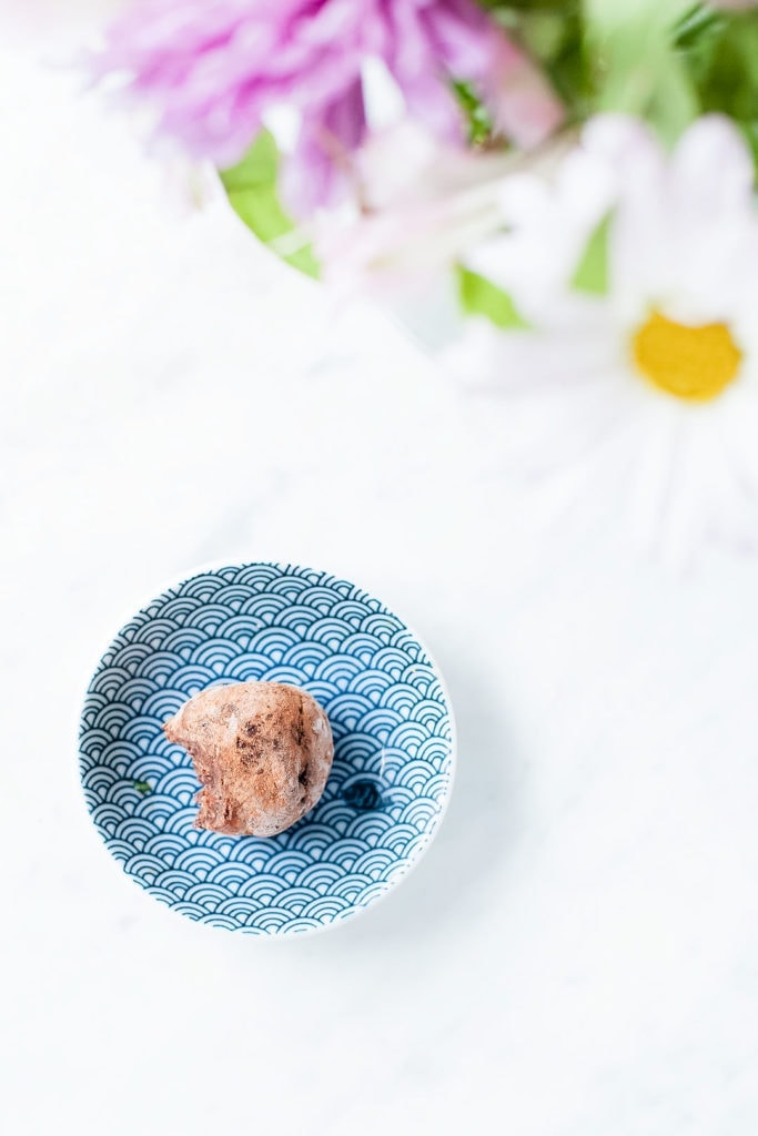 Seed cycling brownie bite on a blue plate with flowers.