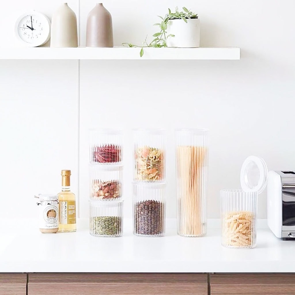 Bulk bin items in jars on a white kitchen counter.