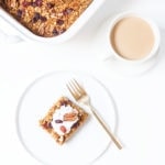 Pumpkin baked oatmeal with coconut whipped cream on a white plate.