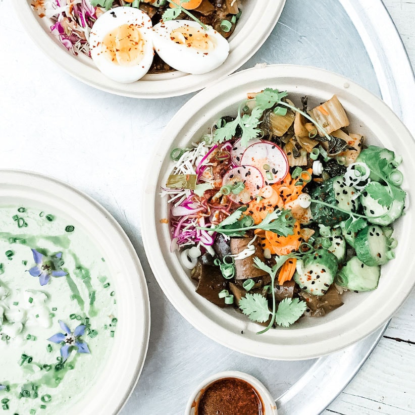 Brown rice veggie bowls from Amber Waves farm on a table.
