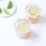 Kombucha margaritas in two cocktail glasses with lime slices.