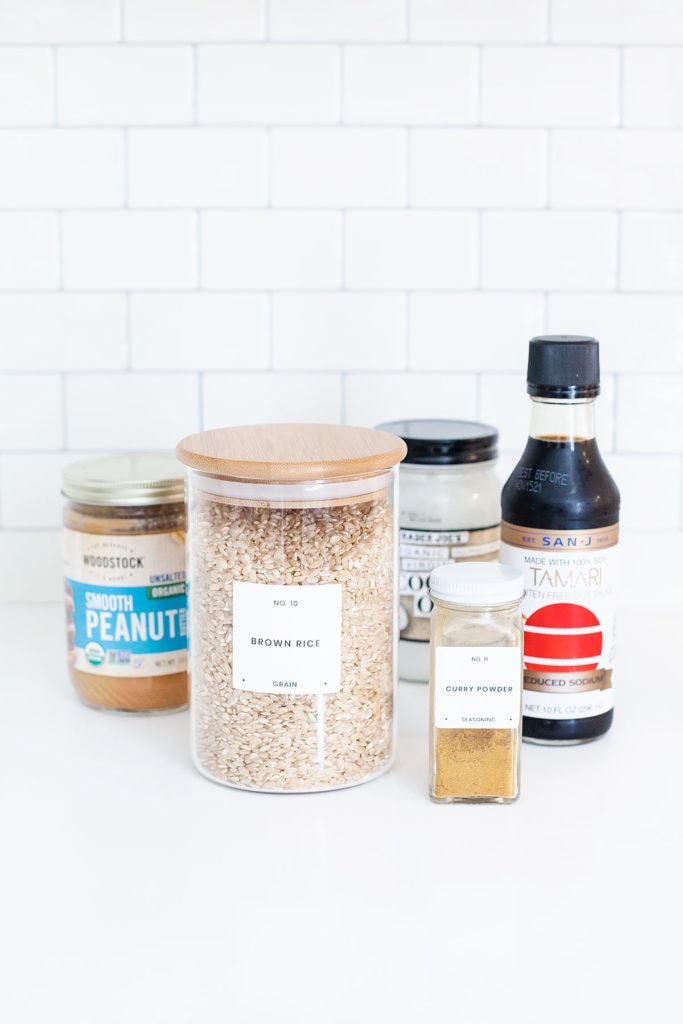 Peanut edamame burger ingredients in jars on a white countertop.