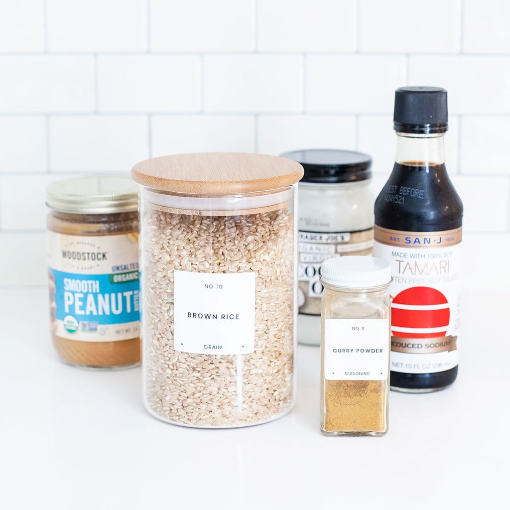 Peanut edamame burger ingredients in jars on a white countertop.