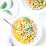 Easy pumpkin chickpea curry in two white bowls with lime slices.