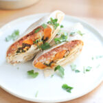 Winter vegetable freezer burritos on a white plate.